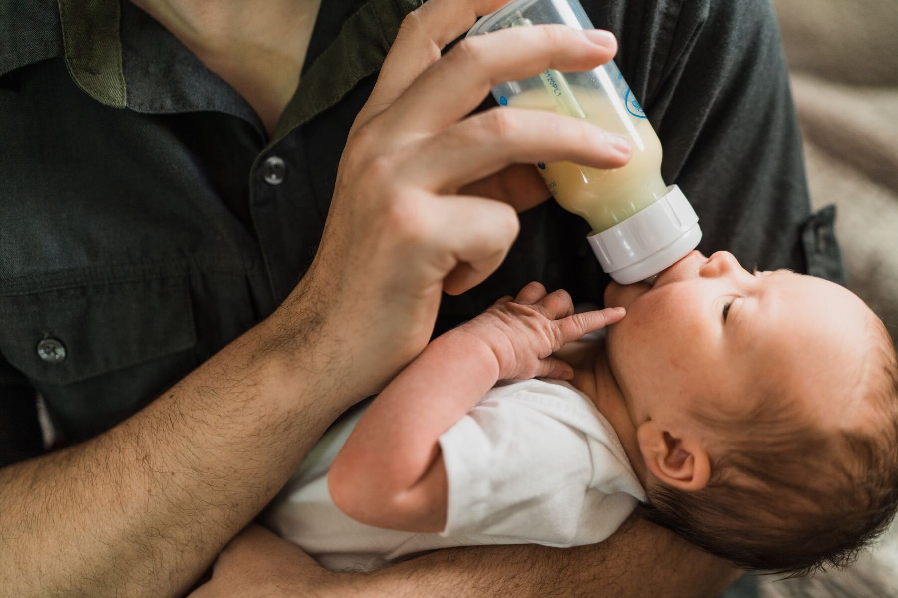 Sammamish newborn in-home photo session dad feeding baby