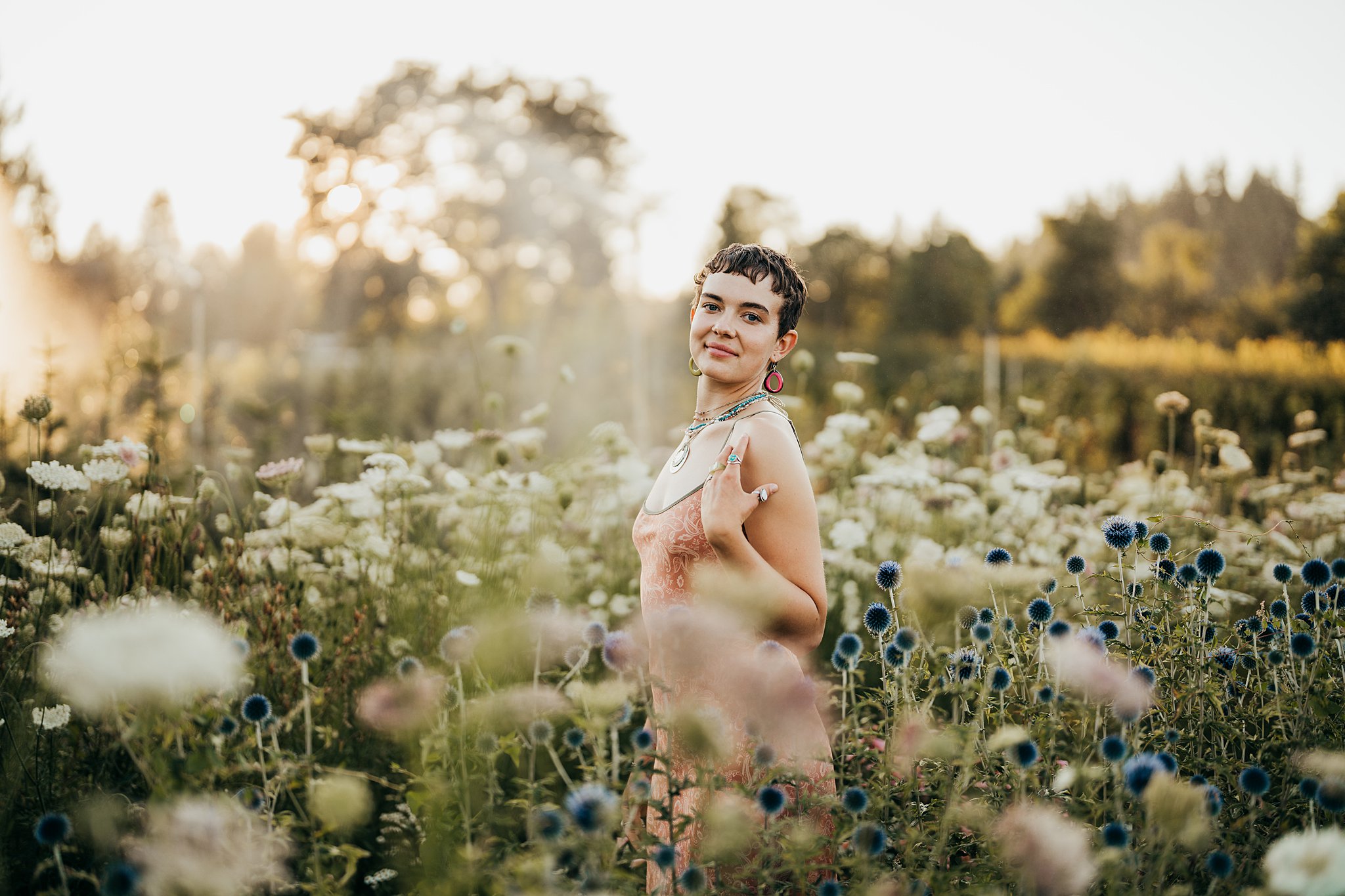 A woman in a red dress stands among white and blue flowers at sunset in a garden Seattle Photoshoot Locations