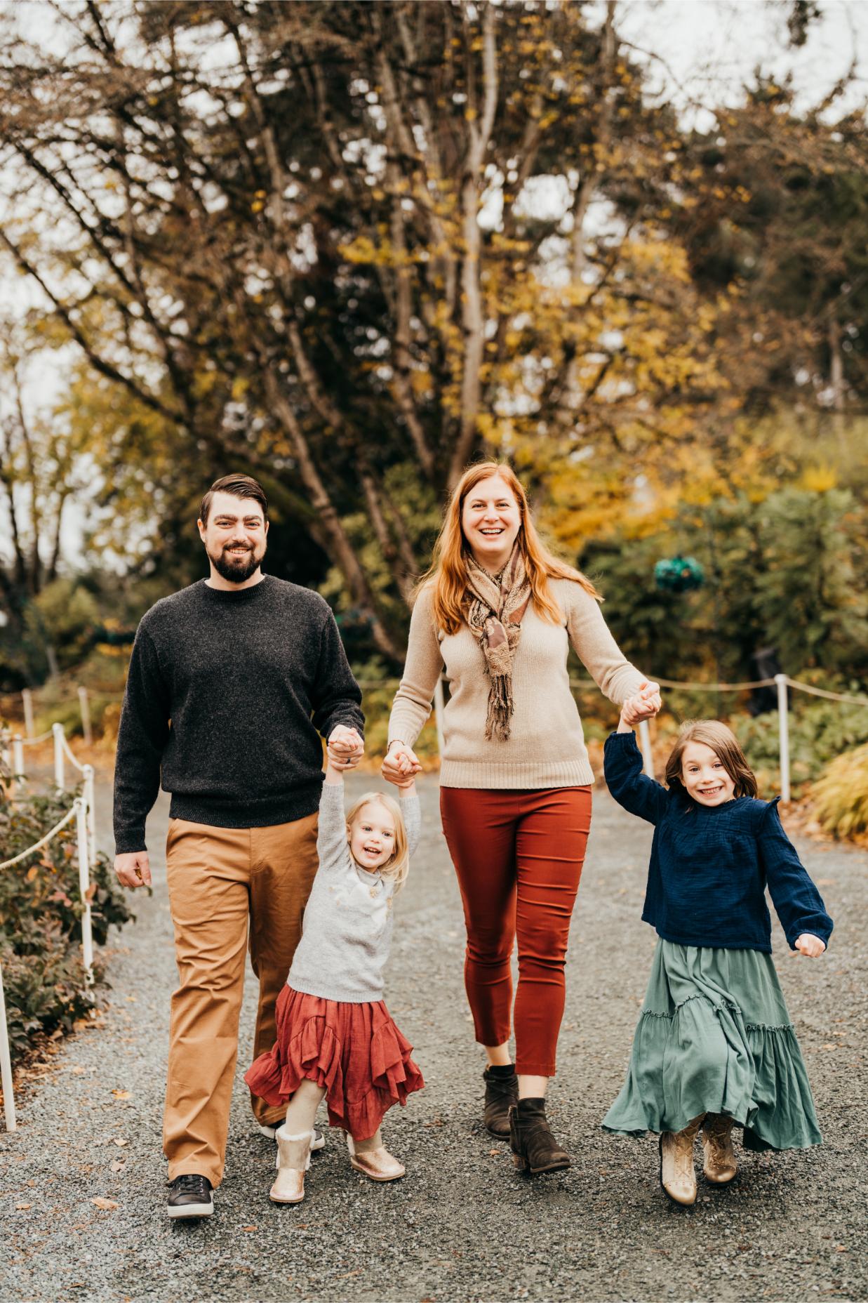 bellevue family of four walking together at Bellevue botanic garden towards camera