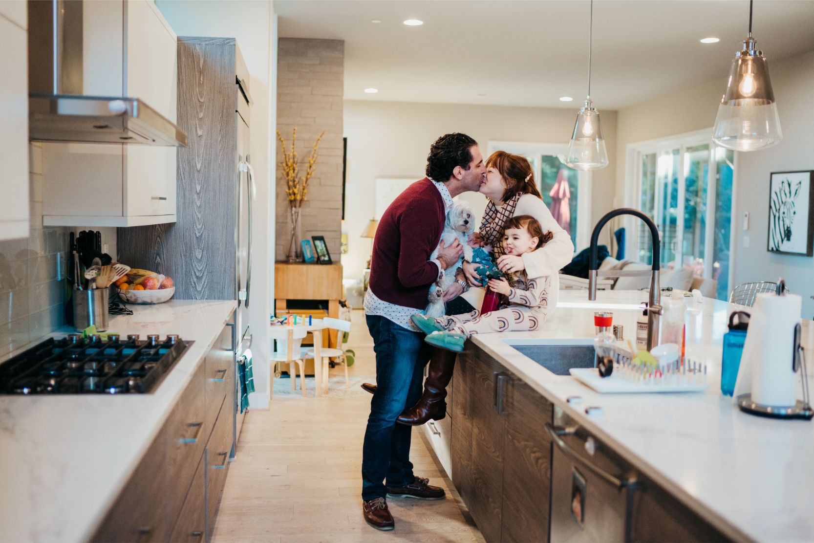 mom dad and children hug in their kitchen and love on each other