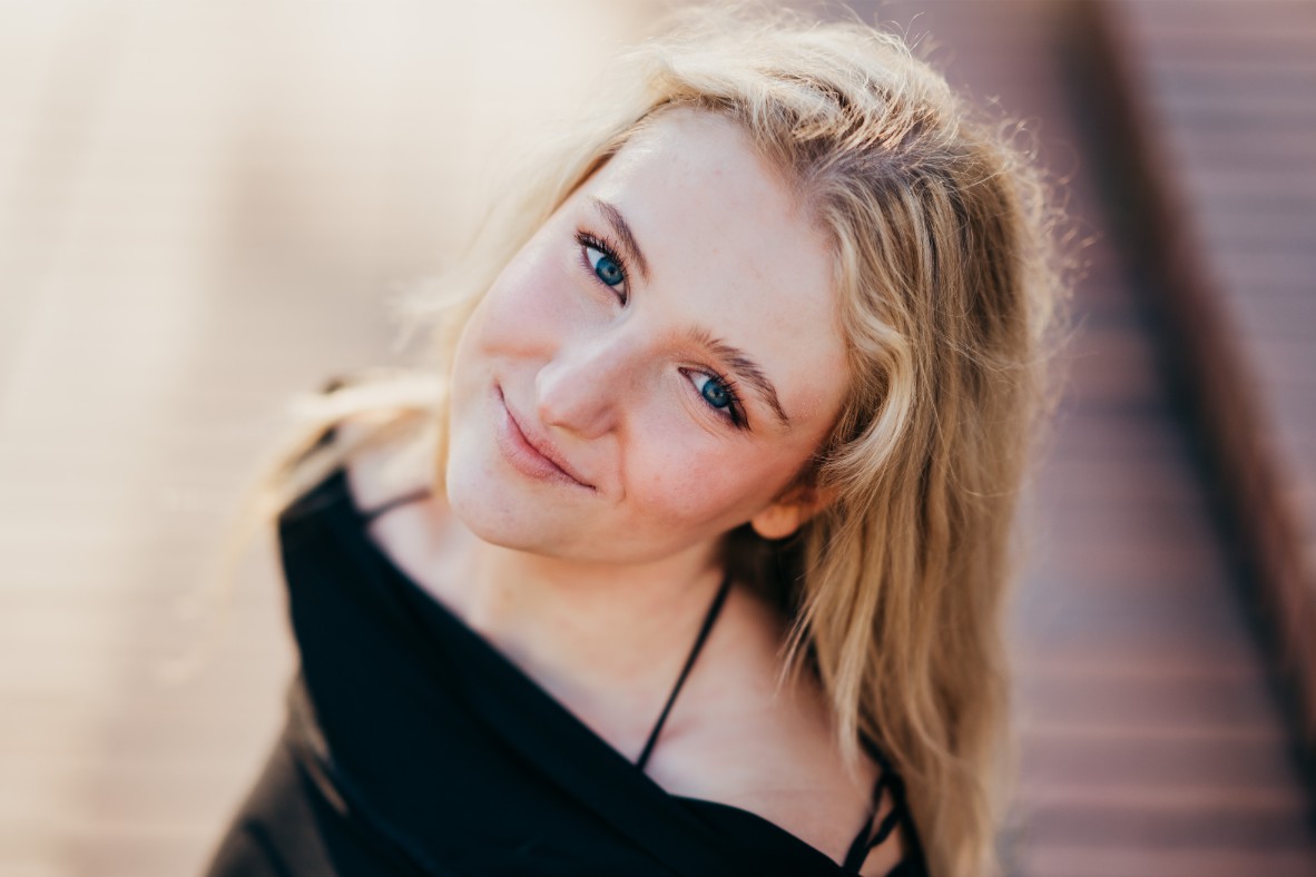 a close up portrait of a high school senior girl with her looking directly at camera at luther burbank park