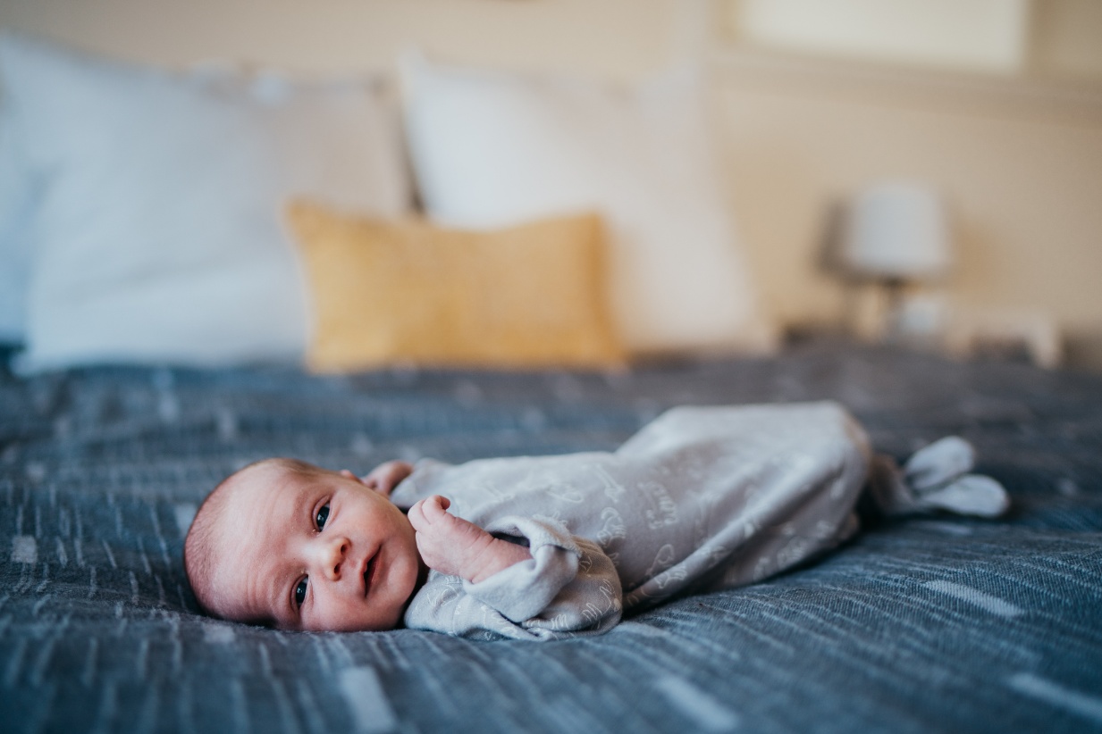 newborn baby boy looking directly at camera at his newborn photo session