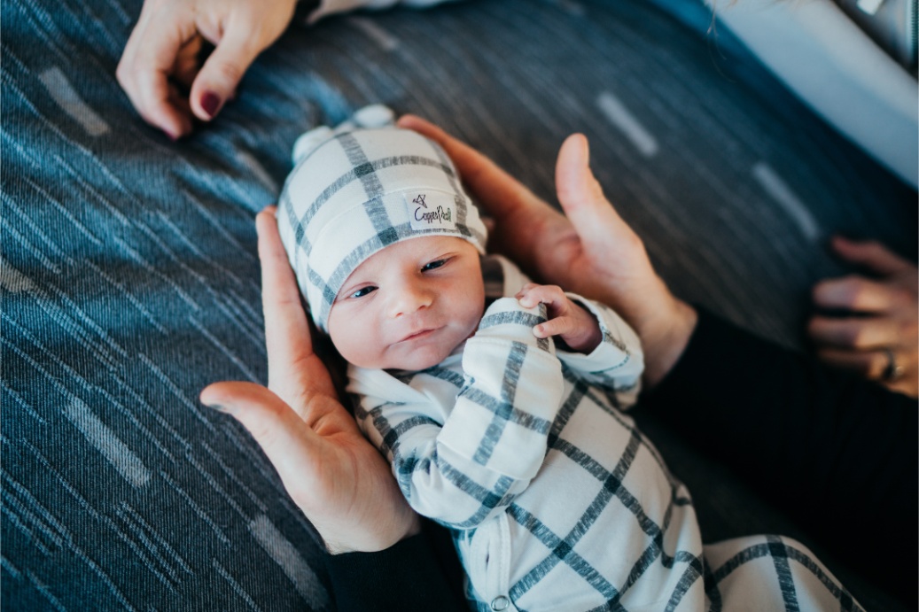 newborn photography prices solo baby portrait lying inside dad's palms