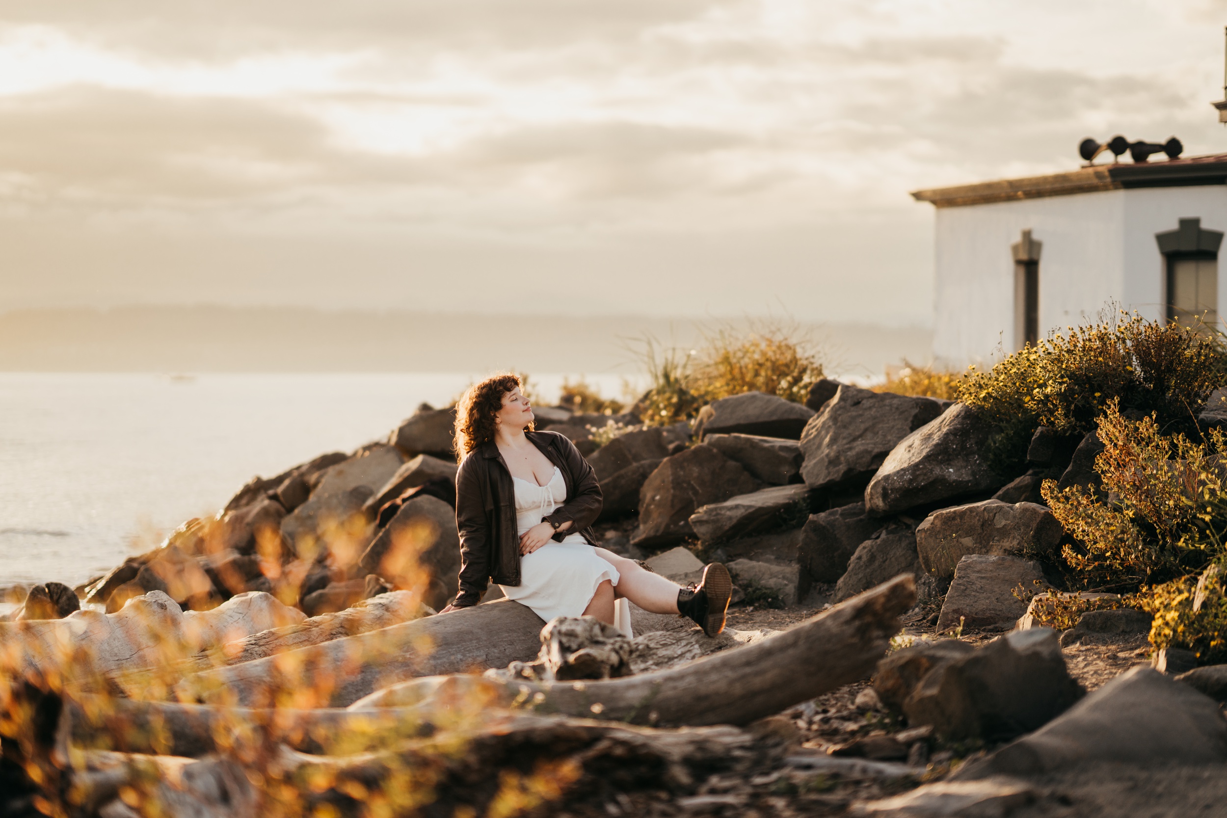 A smiling Garfield High School basks in the sunset while sitting on rocks by the water