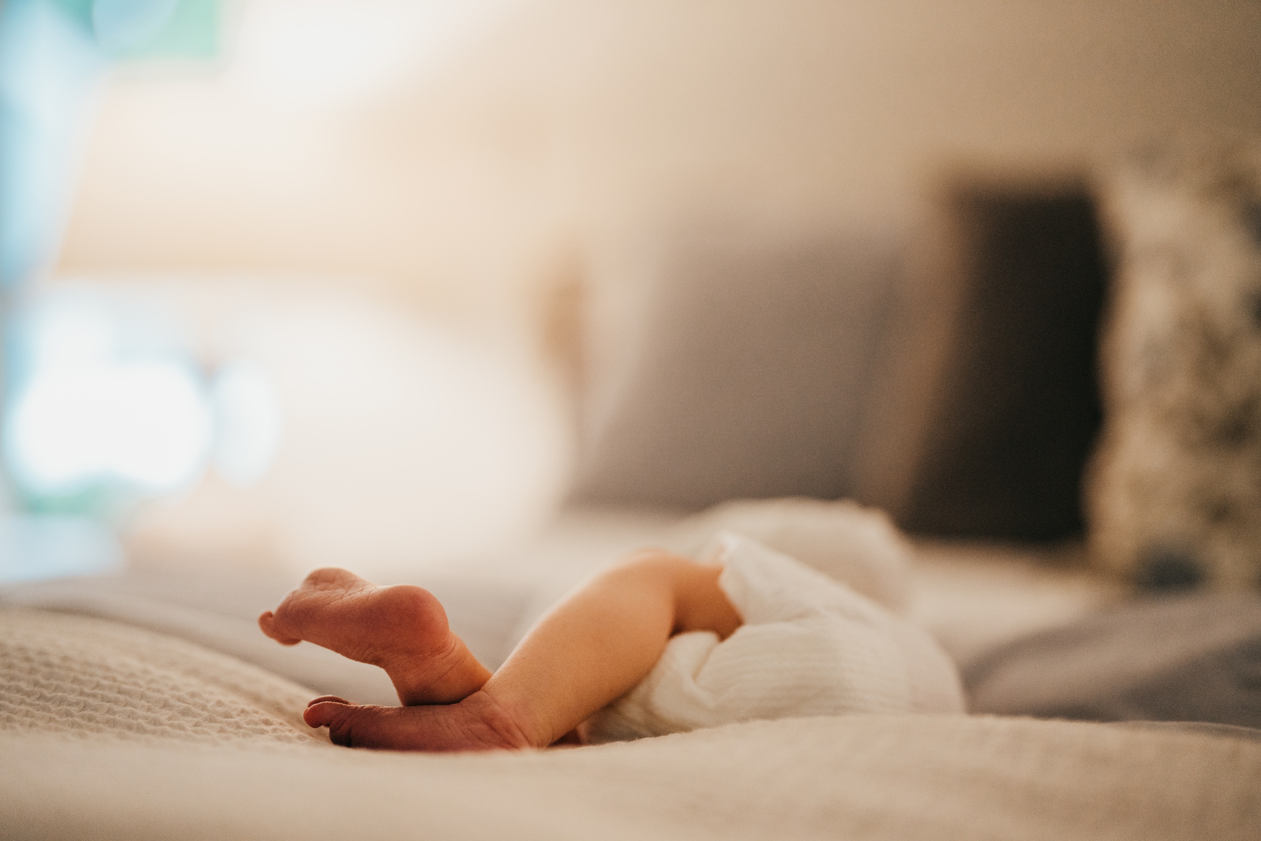 Details of a newborn baby's feet on a bed after visiting pediatric chiropractors in seattle