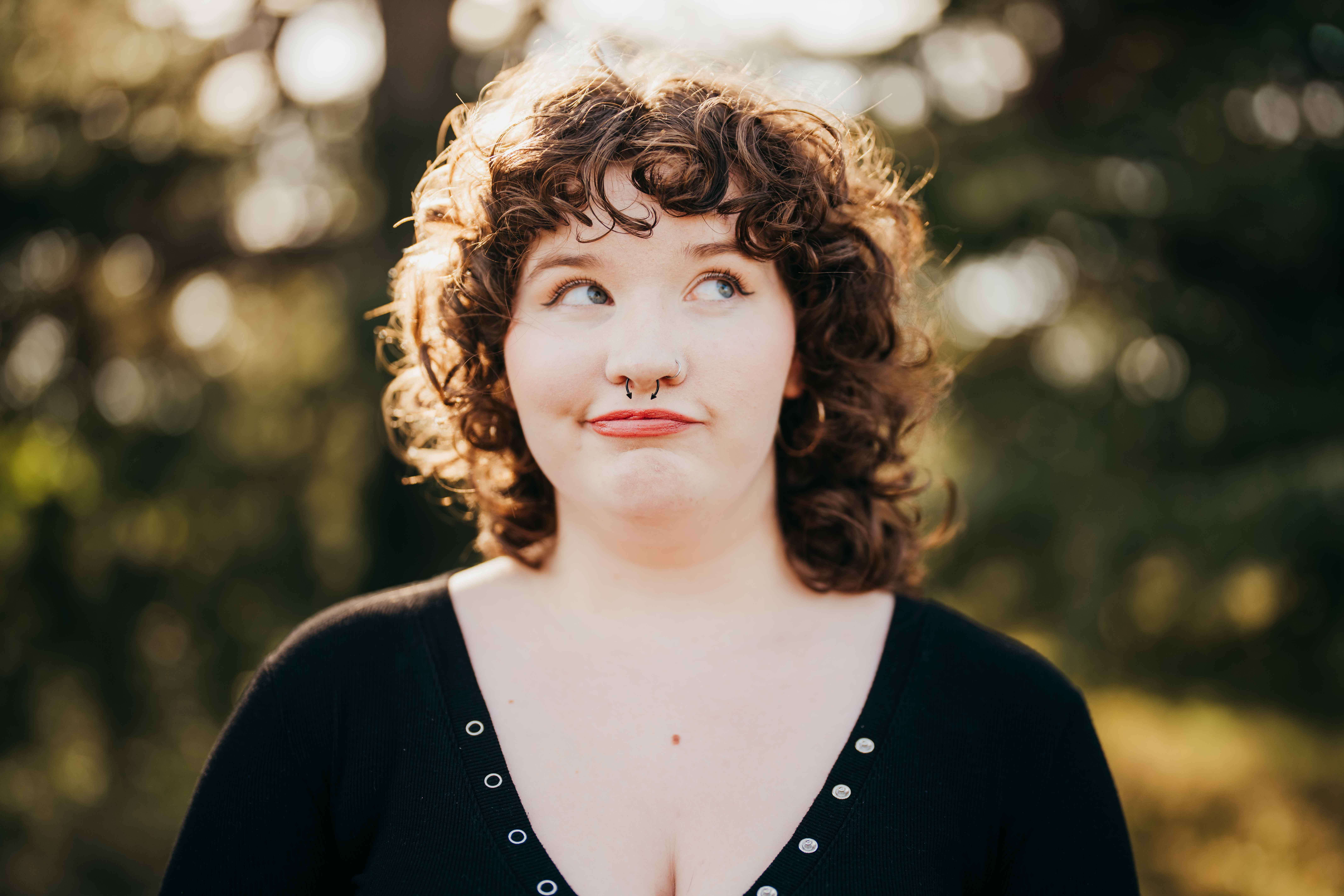 A closeup of a high school senior making a silly face in a black blouse