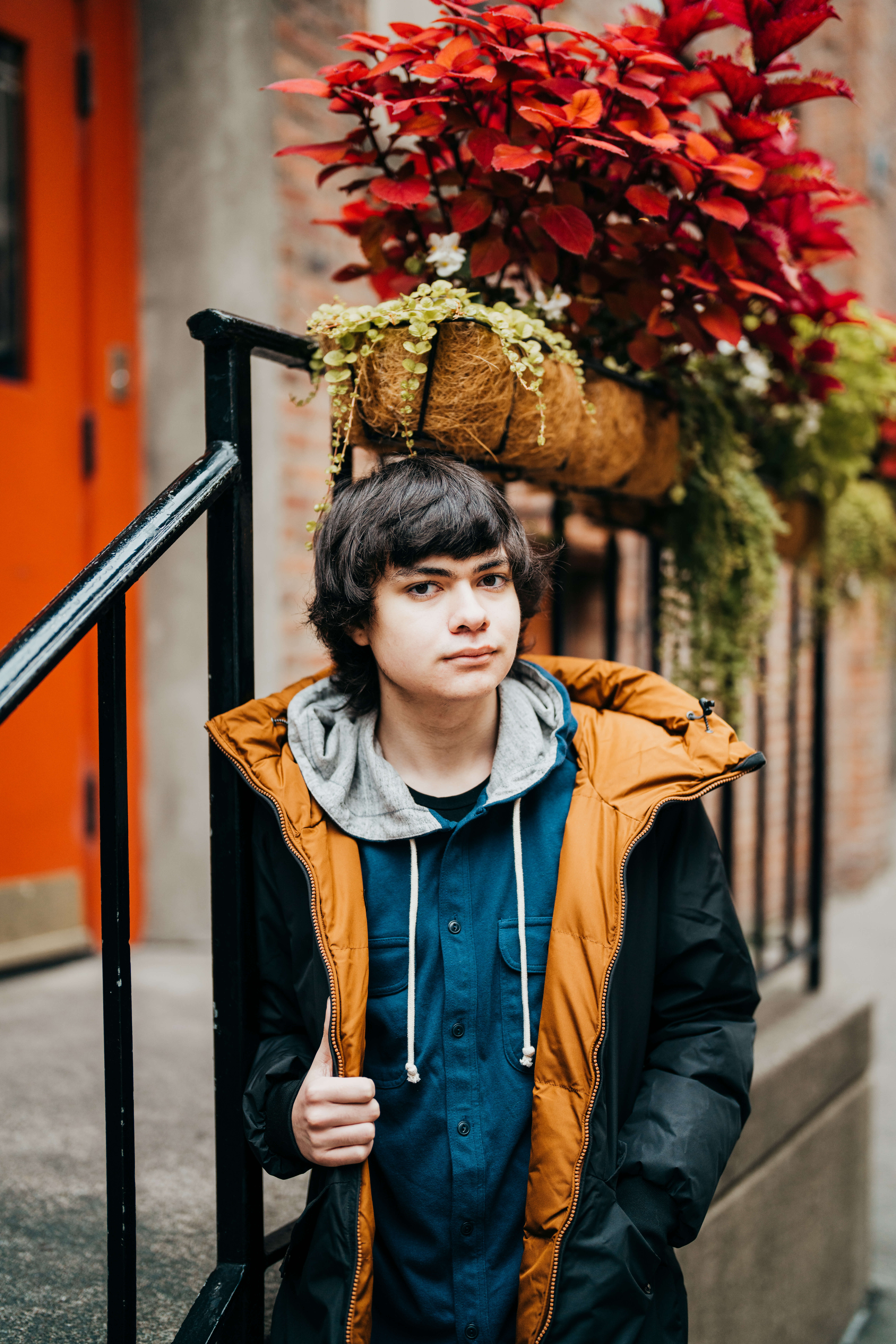A high school senior in blue coats leans on a railing in an alley after taking advantage of cte dual credit