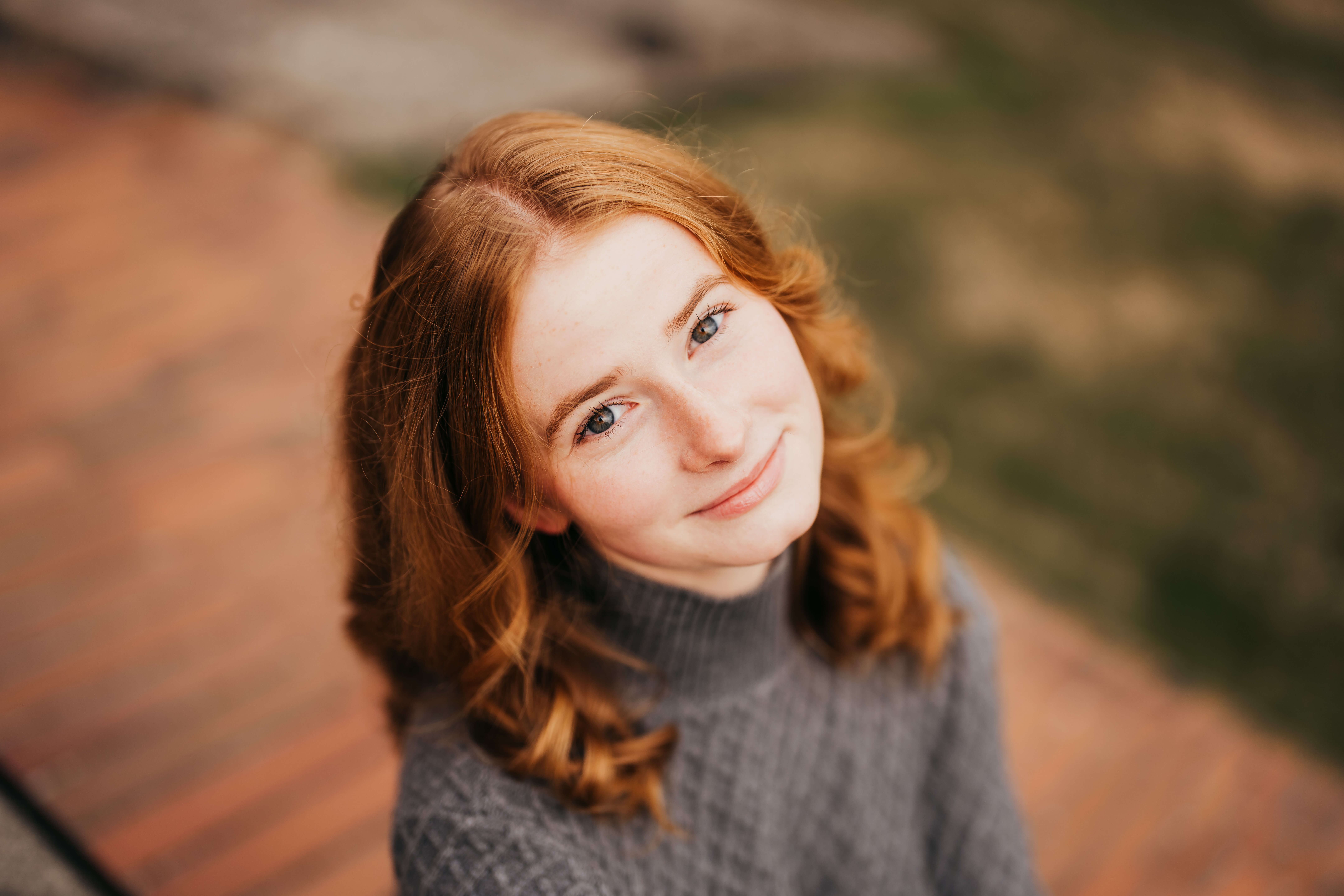 A look down on a high school senior in a grey sweater