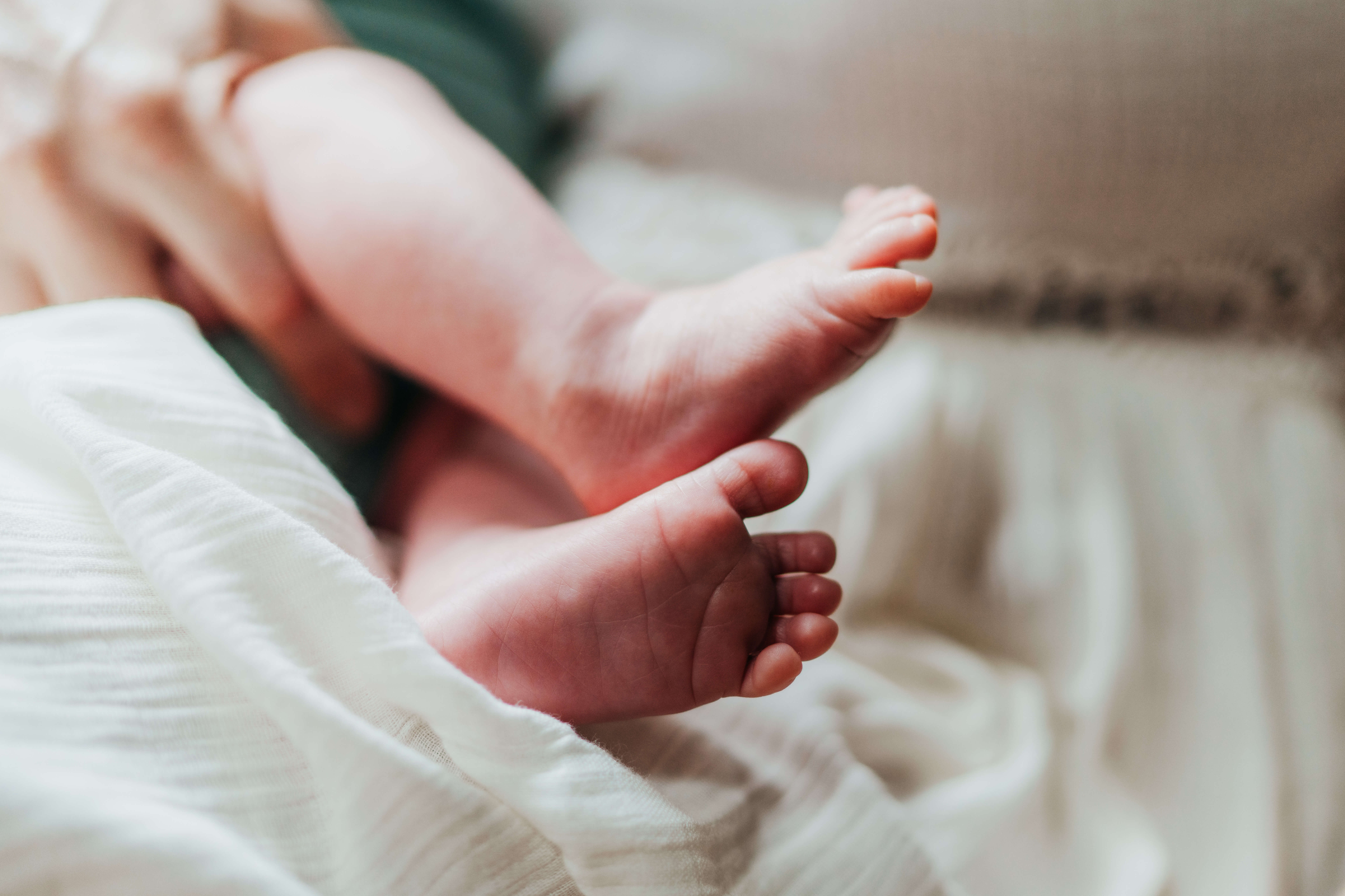Details of a newborn baby's feet while laying in mom's lap after visiting the heybrook seattle